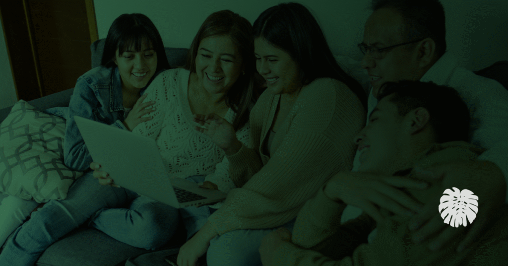 A family gathered in a sofa smiling.