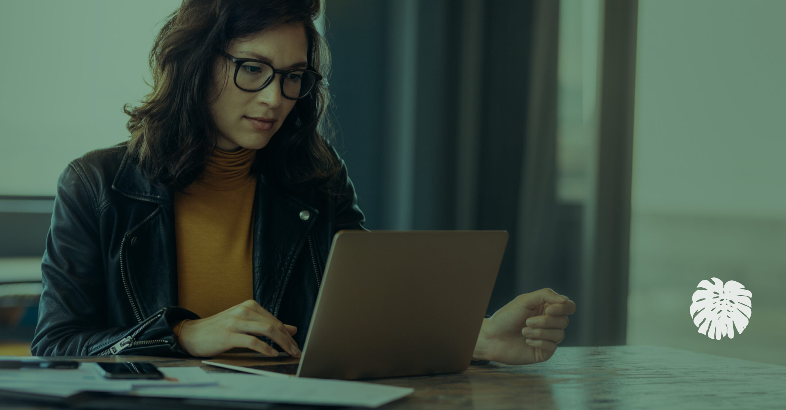 A Hispanic communications professional working on a laptop in an office, representing how school districts use AI translation responsibly.
