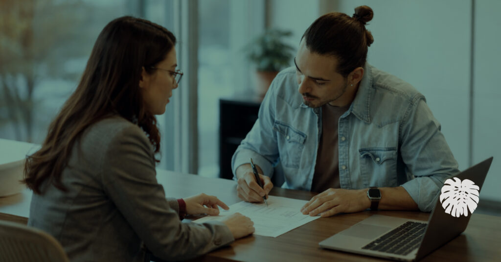HR professional reviewing documents with an employee at a desk, illustrating clear communication and understanding in the workplace.
